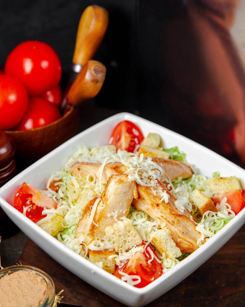 Rotisserie chicken salad with greens and vegetables in a bowl