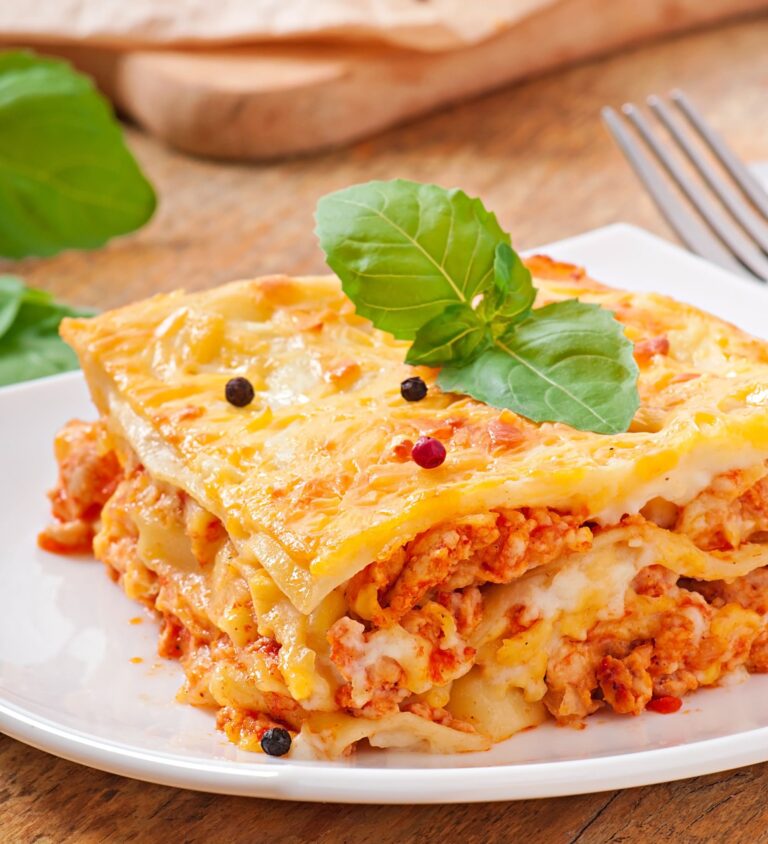 A delicious lasagna slice highlighting its layers with a creamy ricotta cheese blend.