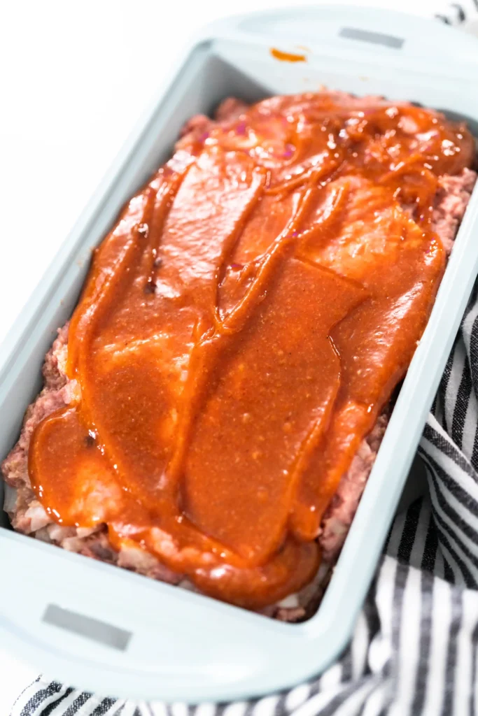 Meatloaf in a baking dish with glaze applied