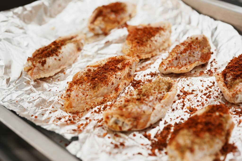 Chicken breasts wrapped in foil on a baking tray.