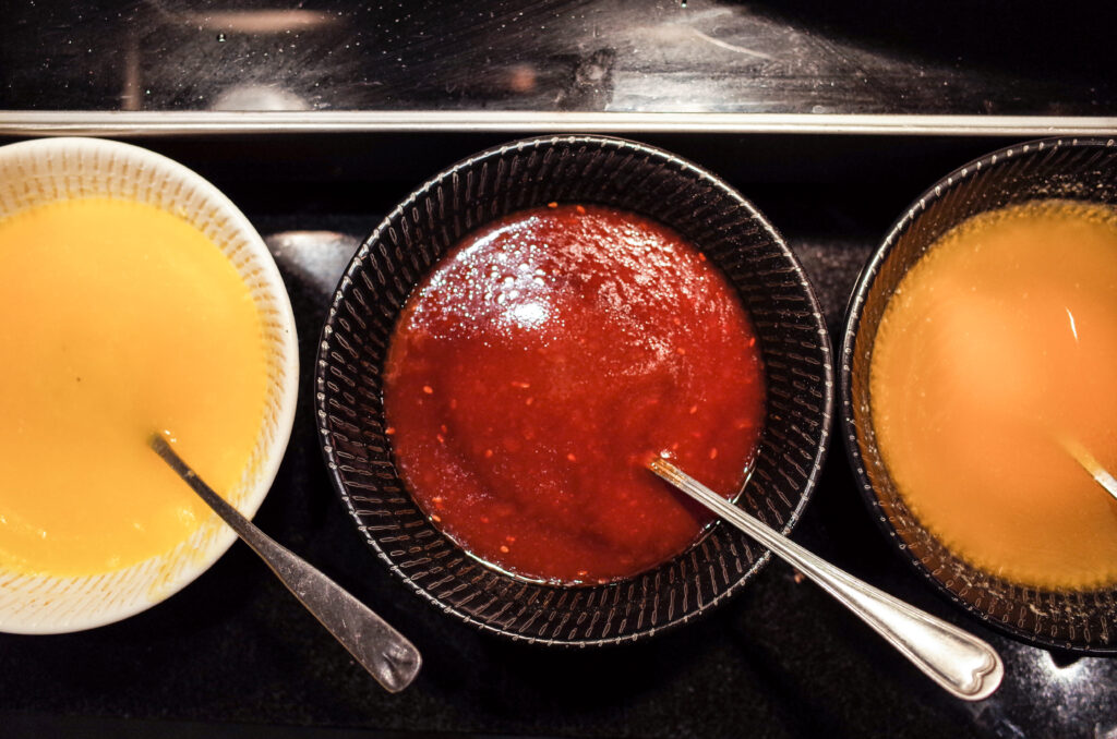 A flat lay of Cajun sauce ingredients, including spices, herbs, and condiments.