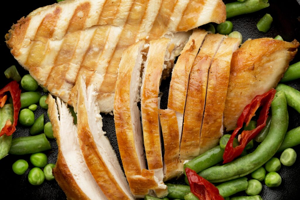 Juicy sliced chicken breasts served with vegetables.