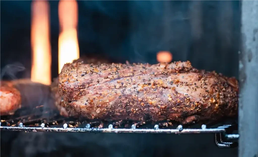 A meatloaf inside a smoker with smoke swirling around