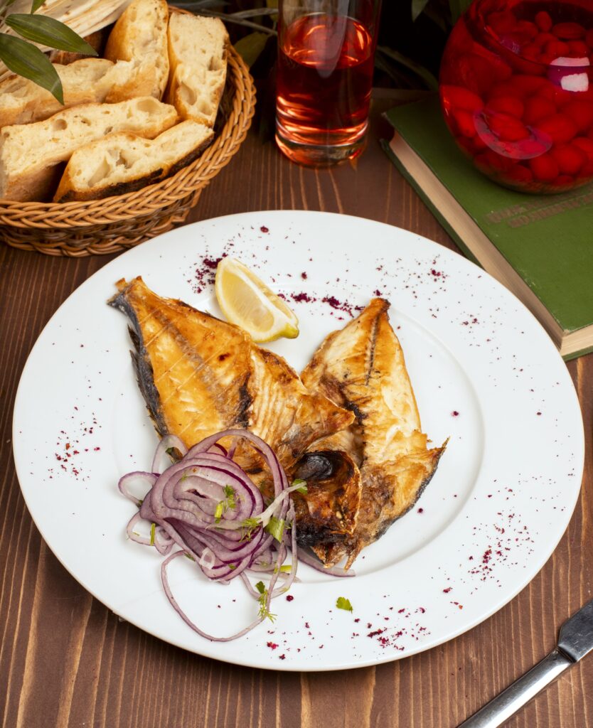 Grilled rockfish fillet on a plate with grilled vegetables.