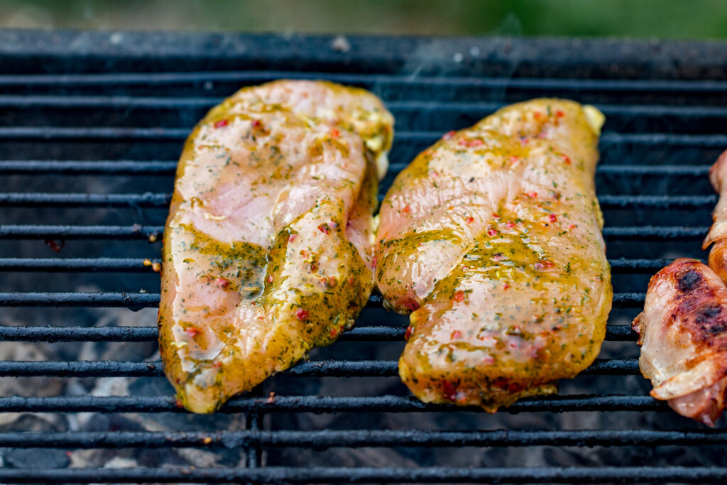 Herb-marinated chicken breasts on a grill.