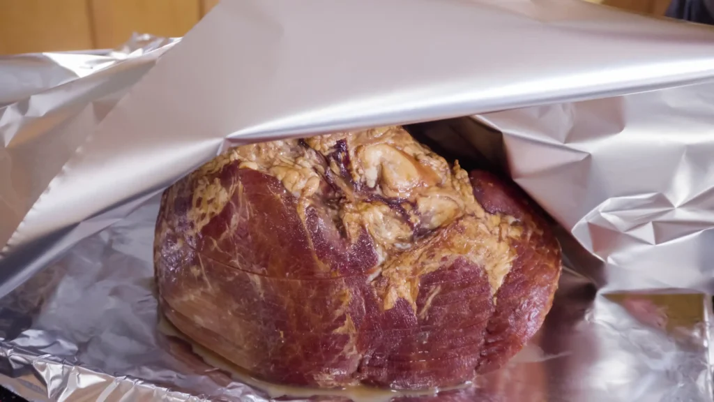 Foil-wrapped meatloaf on a smoker rack.