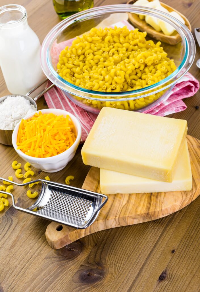 Cheese sauce being whisked in a pan on a stovetop