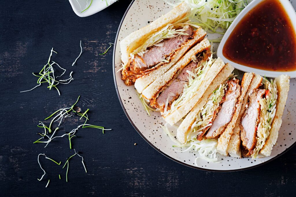 BBQ chicken sliders with coleslaw on a platter.