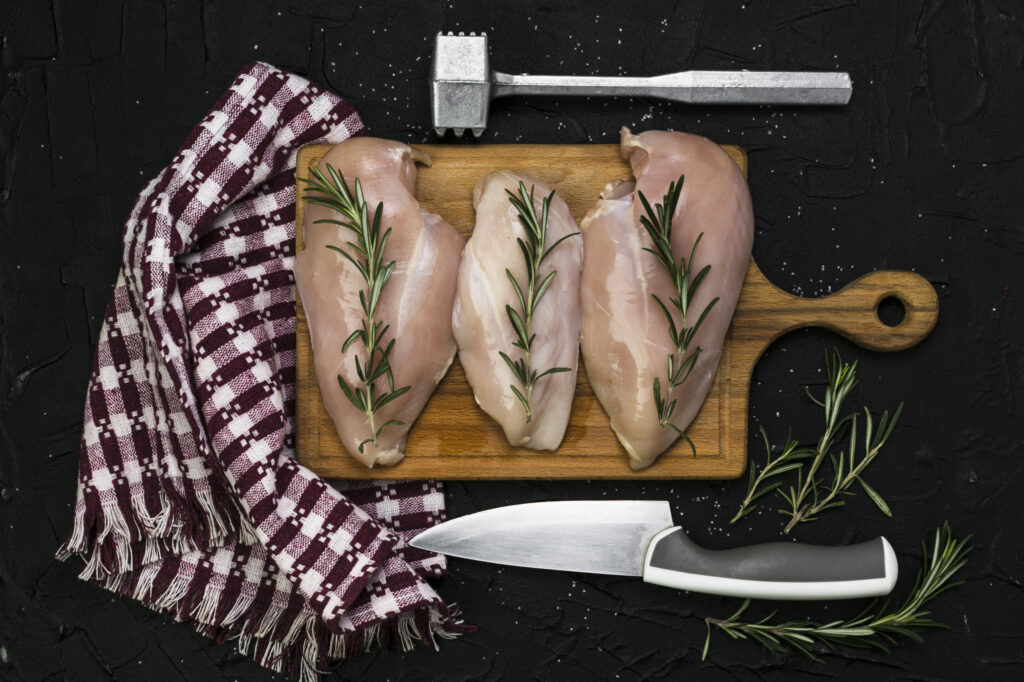 Over-tenderized chicken falling apart on a cutting board.