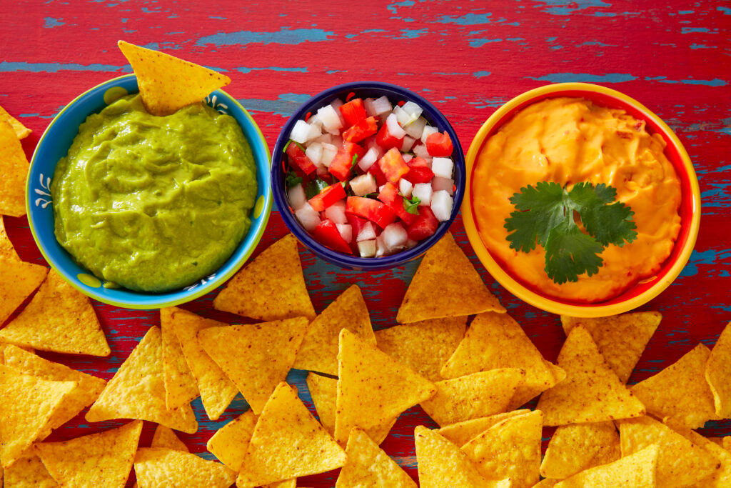 A trio of guacamole, pico de gallo, and queso dip with tortilla chips