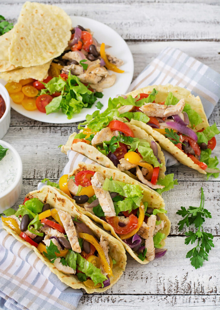 Tacos filled with shredded rotisserie chicken, fresh salsa, and guacamole.