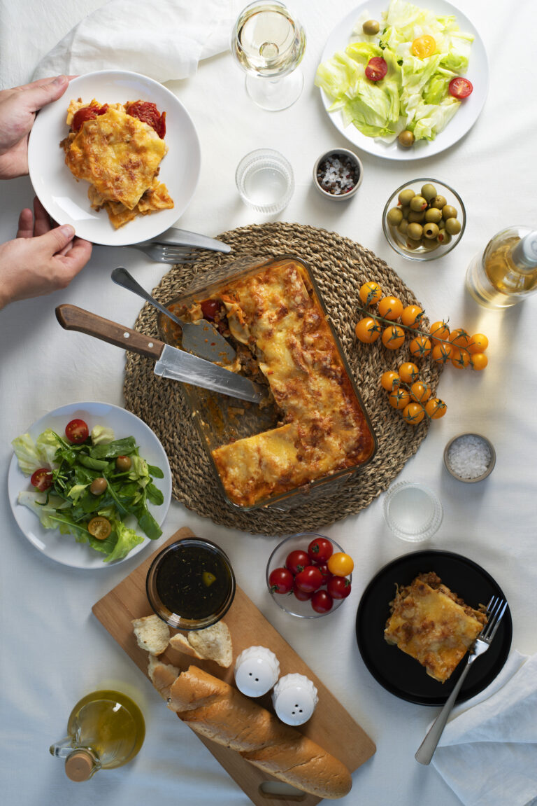 A table spread featuring taco lasagna with various side dishes and drinks