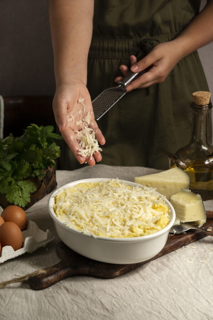 A layered lasagna being prepared with a smooth ricotta and egg layer