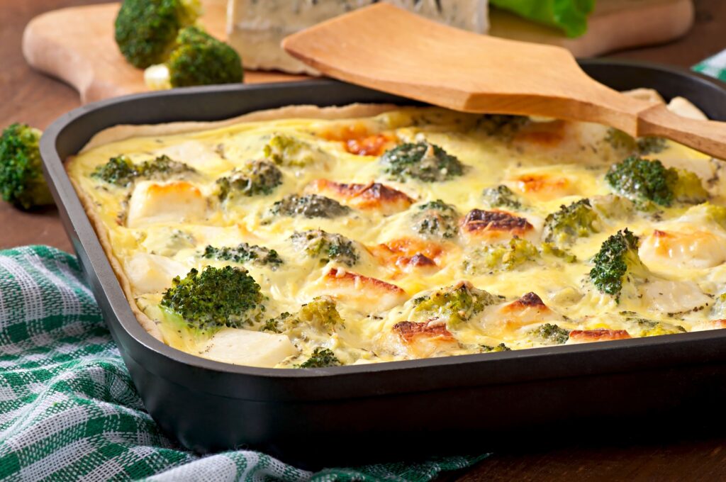 A cheesy chicken and broccoli casserole in a baking dish.