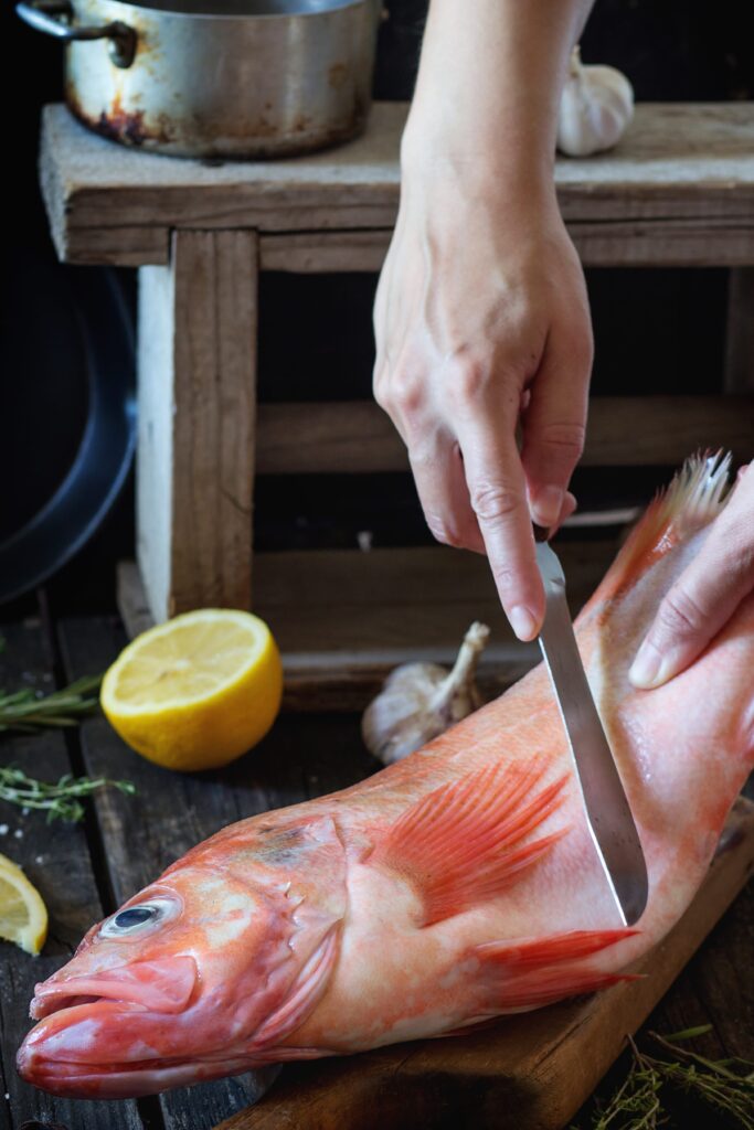 Rockfish fillets in a brine solution with visible salt crystals.