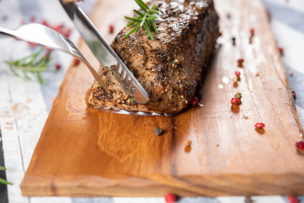 A meatloaf being glazed with a brush mid-bake