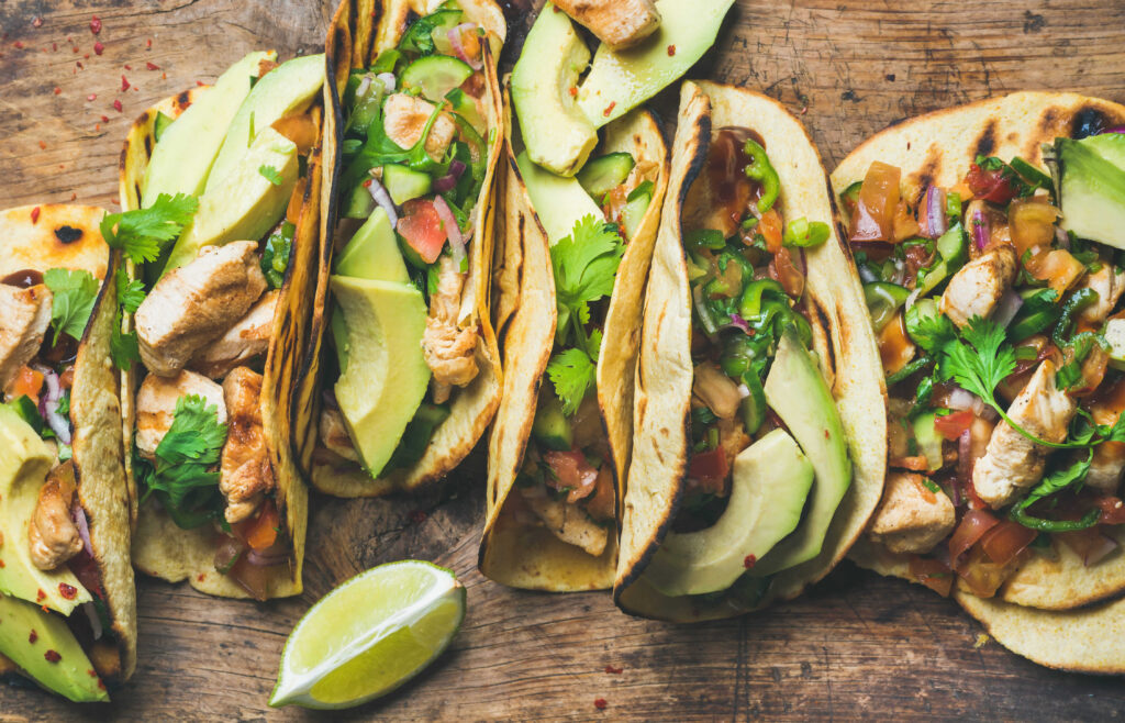 Rotisserie chicken tacos on a plate with fresh toppings