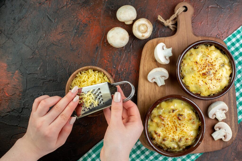 Mac and cheese in a casserole dish being topped with breadcrumbs.